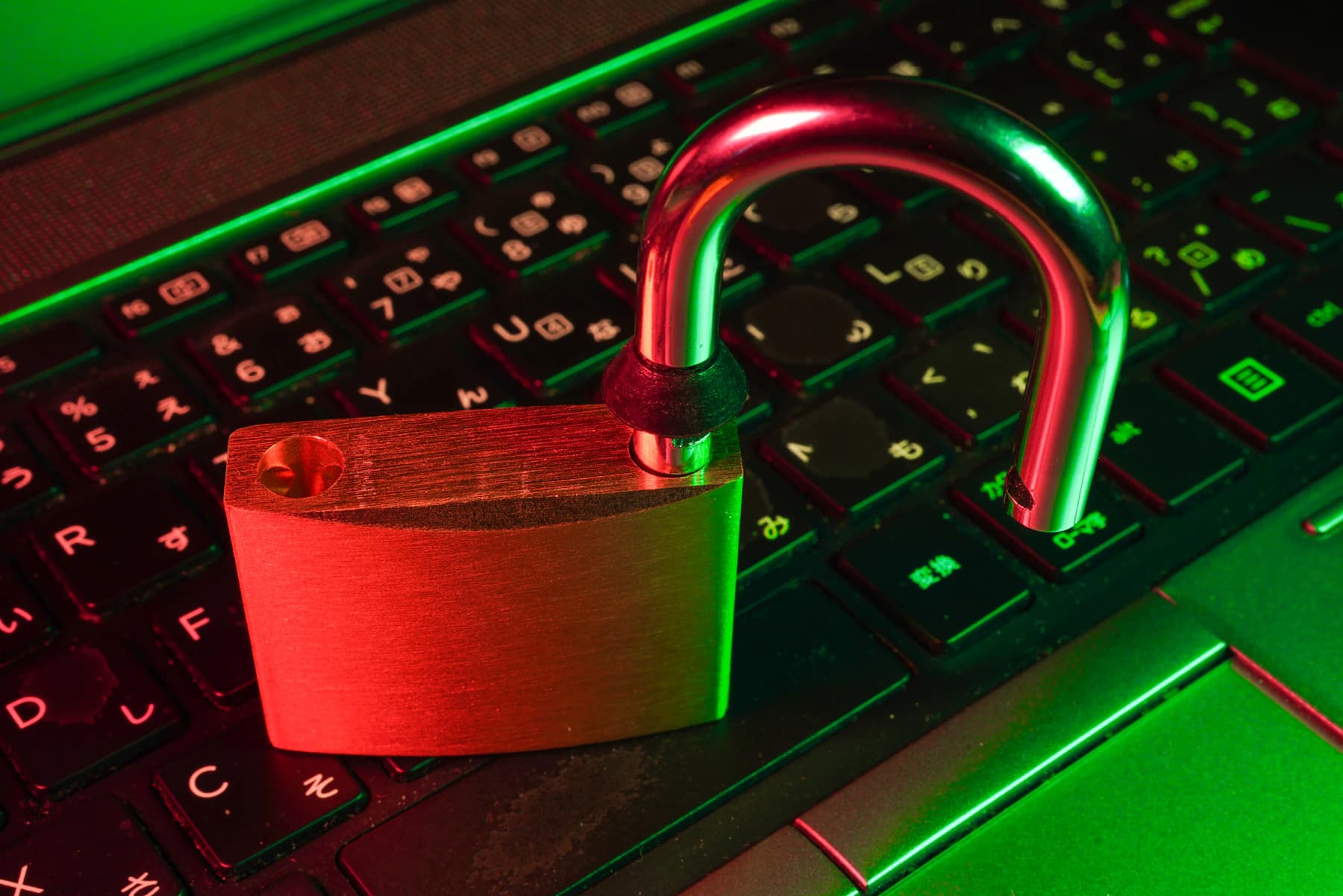 An open padlock resting on a laptop keyboard, an application left unlocked